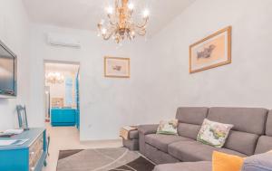 a living room with a couch and a chandelier at Blue Waves Apartment with Maltese Balcony in Valletta