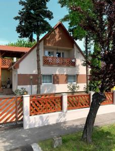 a house with a wooden fence in front of it at Hanna Apartman in Balatonlelle