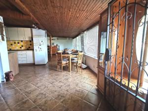 cocina y comedor con mesa y nevera en Самостоятелна къща за гости на 10 минути от плажа en Varna