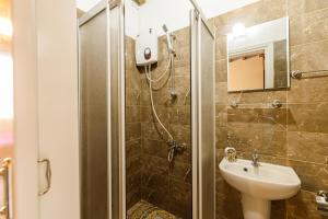 a bathroom with a shower with a sink and a toilet at Santa Napa Guest House in Famagusta