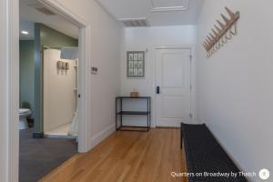 a room with a hallway with a door and wooden floors at West Broadway Quarters by Thatch in Boston