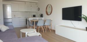 sala de estar con TV, mesa y sillas en Sun & Relax in Denia Beach, en Denia