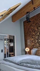 a bedroom with a large bed and a wall with a gold design at Appart-Hotel REB_ART in Deidesheim