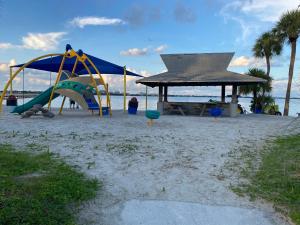a playground with a slide and a pavilion on the beach at This Homestay Oasis Is The Cape's Best Place To Stay in Cape Coral