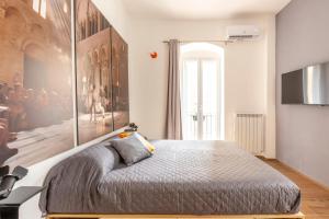 sypialnia z łóżkiem z dużym obrazem na ścianie w obiekcie Just Here apartments - Lascia Fare a Dio w mieście Bari
