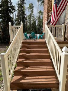 a wooden staircase with an american flag on a house at Brian Head Cabin - 1 Mile from ALL SKI LIFTS! Cozy, Spacious & lots of fun in Brian Head