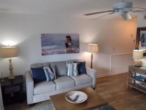 una sala de estar con sofá y una pintura en la pared en Sandpeddler Inn and Suites en Wrightsville Beach