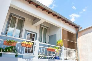 une maison blanche avec des plantes en pot sur un balcon dans l'établissement Hôtel Croix Baragnon, à Toulouse