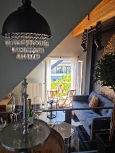 a living room with a blue couch and a chandelier at Appart-Hotel REB_ART in Deidesheim