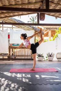 a woman doing a yoga pose on a yoga mat at Casa Nomade in Itarema