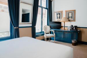 a hotel room with a bed and a desk and window at Paleis Hotel in The Hague