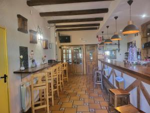 un bar dans un restaurant avec tabourets en bois dans l'établissement Hotel rural la casona de Tamaya, à Tamajón