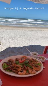 a plate of food on a table at the beach at Apê de Mainha in Ilhéus