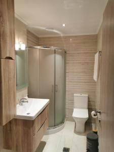 La salle de bains est pourvue de toilettes, d'un lavabo et d'une douche. dans l'établissement SUNSET Luxury Accommodation, à Verga Kalamata