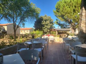 una fila de mesas y sillas en un patio en Hotel rural la casona de Tamaya en Tamajón