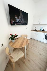 kuchnia z drewnianym stołem, stołem i krzesłami w obiekcie White Apartments w mieście Katowice