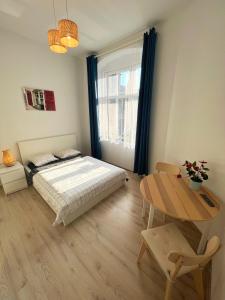 sypialnia z łóżkiem i stołem w obiekcie White Apartments w mieście Katowice