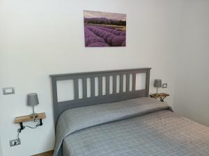 a bedroom with a bed with purple flowers on the wall at B&B Il Ghiro in Riolunato