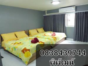 a bedroom with two beds with stuffed animals on them at K.NAT Room service in Nonthaburi