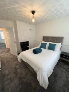 a bedroom with a large white bed with blue pillows at Serene Property Next to Southampton General Hospital in Southampton