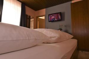 a close up of a bed with pillows on it at Landgasthof Grüner Baum in Regnitzlosau