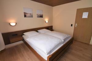 Cama grande en habitación con 2 almohadas en Landgasthof Grüner Baum, en Regnitzlosau