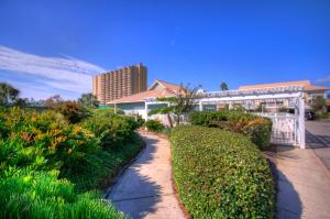 a garden with bushes and a building in the background at St Martin Beachwalk Villas 432 in Destin