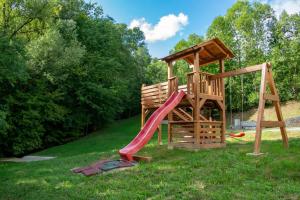 ein Spielplatz mit Rutsche und Spielstruktur in der Unterkunft Liniștea Codrului in Borşa