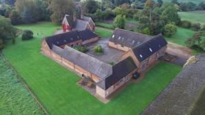 an aerial view of an old building on a field at Somersal Cottages in Ashbourne