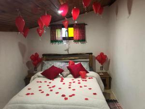 a bedroom with red hearts on a bed with balloons at Chalé jeito de roça na Pedra Selada in Visconde De Maua