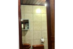 bagno con servizi igienici, lavandino e specchio di Chalé jeito de roça na Pedra Selada a Visconde De Maua