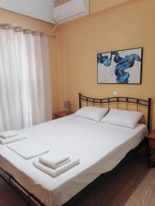 - une chambre avec un grand lit blanc et des serviettes dans l'établissement Spacious Apartment Archidamoy 114, à Sparte