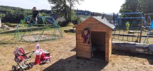 una mujer está parada en una casa de perros en un patio de recreo en Les gîtes de la commanderie de Saint Jean SCAFER en Beynat