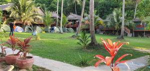 a resort with palm trees and people in a park at Khim Vouch Ay Rabbit island in Kep