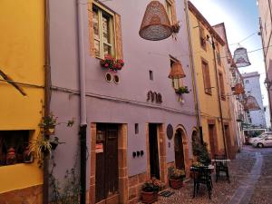 an alley with a pink building with flowers on it at Casa Pagiò in Bosa