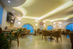 un comedor con mesas, sillas y ventanas en Sowirad hotel, en Addis Ababa