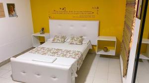 1 dormitorio pequeño con 1 cama blanca y 2 almohadas en Hotel El Exito, en Santa Marta