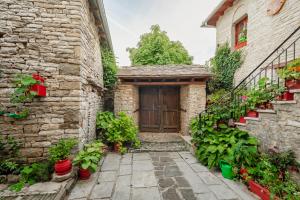 een toegang tot een stenen huis met een houten deur bij Archontiko Rapti Stone Traditional House in Monodendri