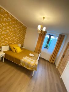 a bedroom with a bed with a yellow blanket and a window at Lu Residence - Unique Apartments in Oświęcim