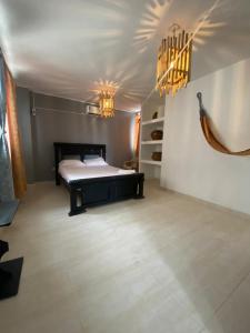 a bedroom with a bed and two chandeliers at Hotel El Exito in Santa Marta