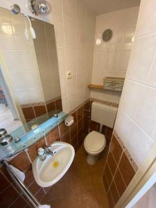 a bathroom with a sink and a toilet and a mirror at Sailor apartments in Pag