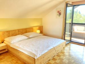 a bedroom with a large bed with a large window at Ferienwohnung Sima in Velden am Wörthersee