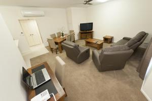 a living room with a couch and a table and a television at Apartments on Palmer in Rockhampton