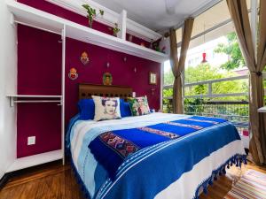 1 dormitorio con 1 cama grande y paredes moradas en Casa ITZAE B&B- Lincoln Park dog friendly, en Ciudad de México