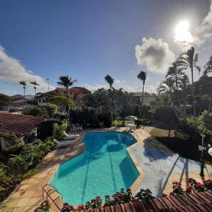 a swimming pool in a resort with palm trees at Pousada Chez Moi in Cabo Frio