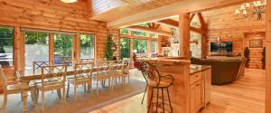 a dining room and living room of a log cabin at Edelweiss Lodge in Boyne Falls