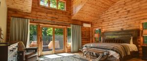 a bedroom with a bed in a log cabin at Edelweiss Lodge in Boyne Falls