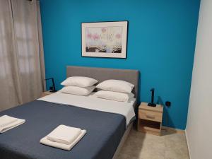 a blue bedroom with a large bed with white pillows at Asterios House in Kriopigi