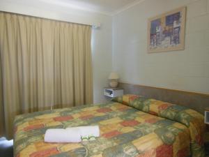 a hotel room with a bed and a lamp at Country Road Motel in Charters Towers