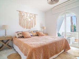 a bedroom with a bed with an orange bedspread at Gorgeous townhouse with shared pool in the middle of Marbella All yours in Marbella